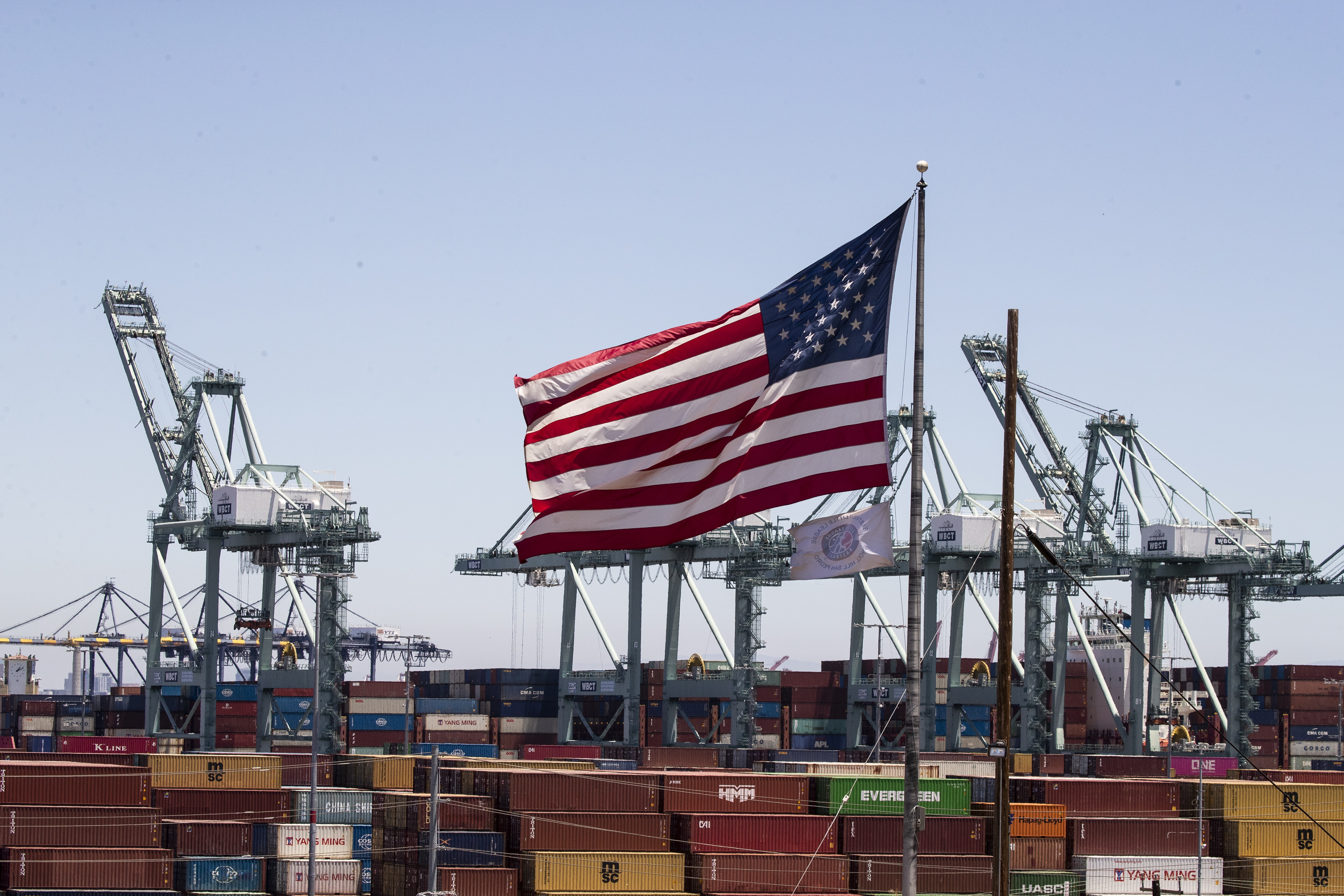 Vista de la bandera de Estados Unidos en el puerto comercial de Los Ángeles, uno de los principales centros de comercio exterior de EE.UU., en una fotografía de archivo. EFE/Etienne Laurent