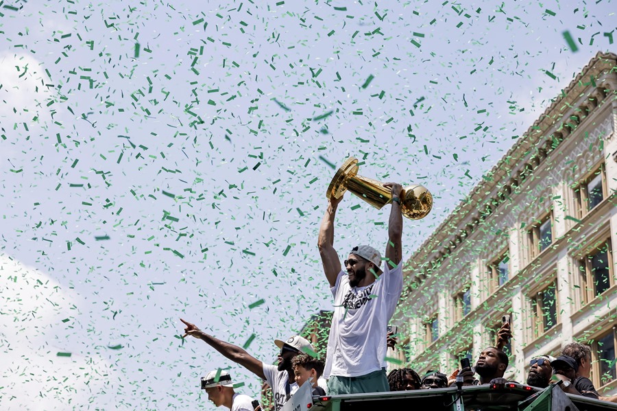 Jayson Tatum, sostiene el Trofeo Larry O'Brien mientras participa en el desfile del Campeonato de la NBA del equipo en Boston, Massachusetts,