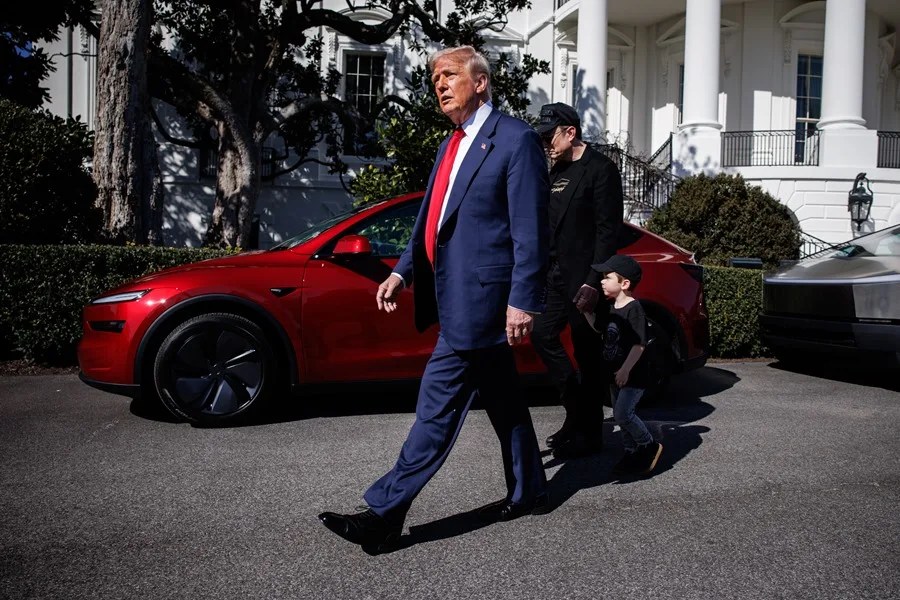 Fotografía de archivo del presidente de EE.UU., Donald Trump (i), caminando junto al magnate Elon Musk (d), con un vehículo Tesla de fondo.