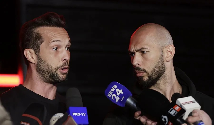 Andrew Tate (der.), acompañado de su hermano Tristan (izq.), habla con reporteros de televisión