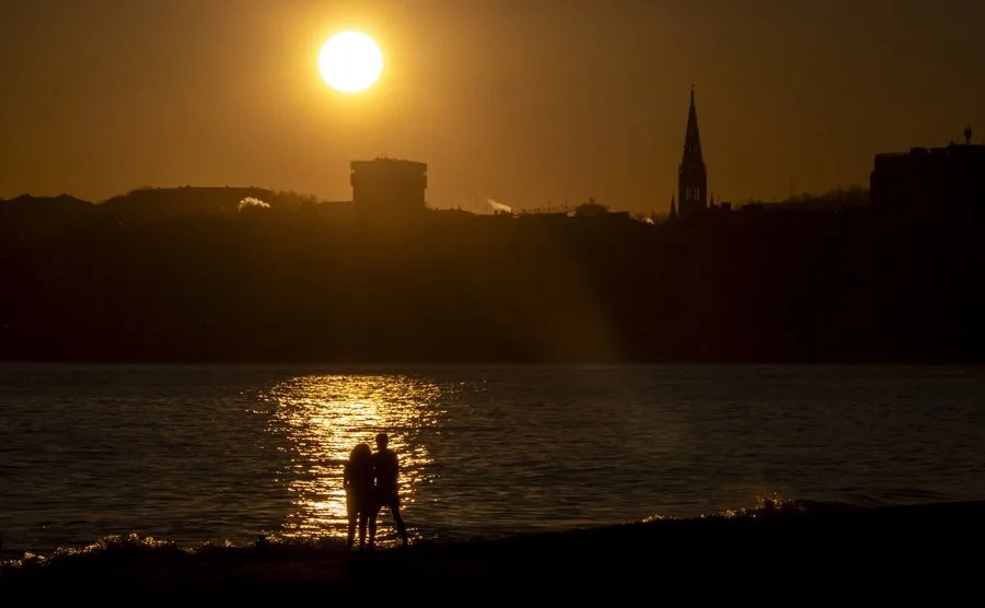Una pareja observa el amanecer este martes en San Sebastián.