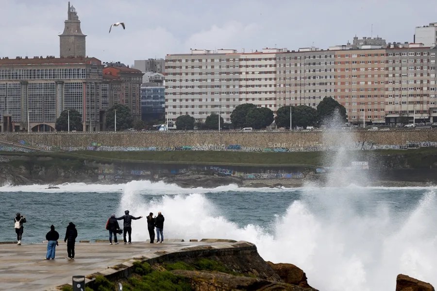Varias personas se asoman al mar en el paseo marítimo de A Coruña
