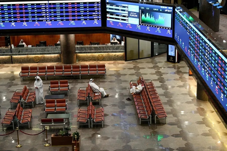 Operadores kuwaitíes observan el mercado de valores en la sala de negociación de la Bolsa de Valores de Kuwait