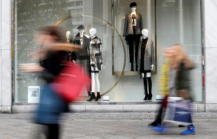 Varias personas camina junto al escaparate de una tienda