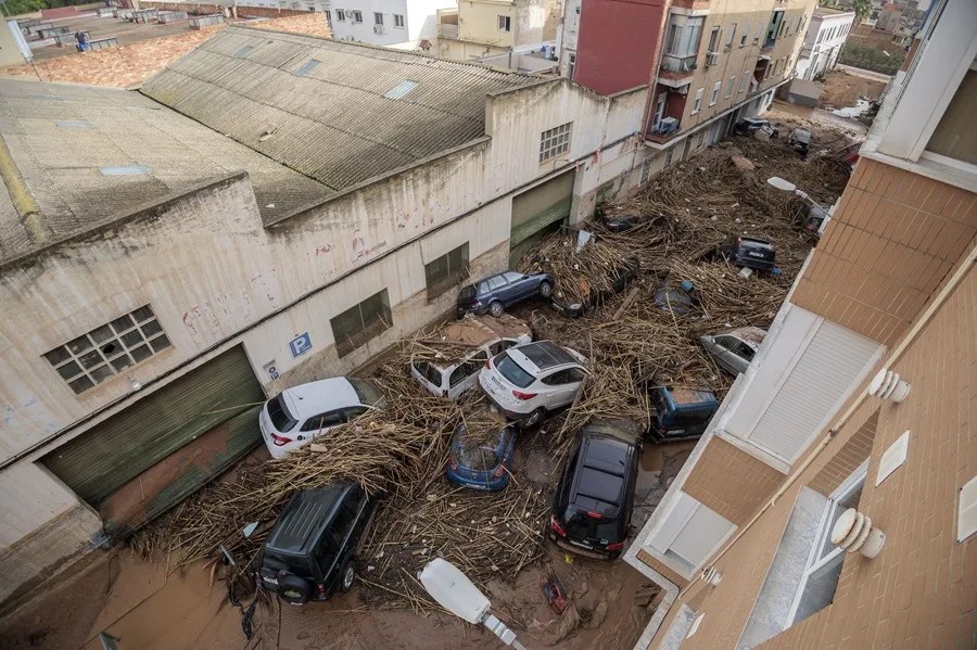 Vehículos y ramas bloqueaban por completo el paso en una calle en Paiporta el 30 de octubr