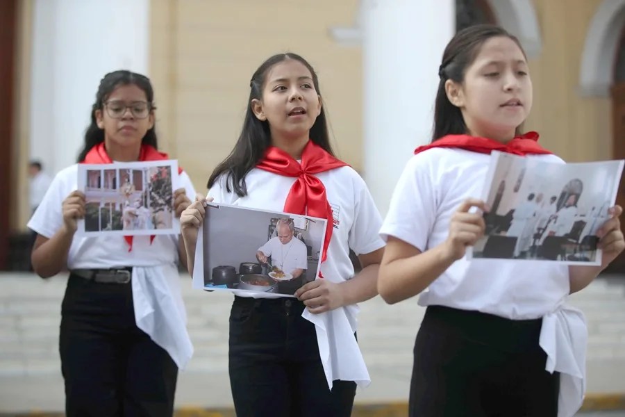 Niños sostienen fotos del papa León XIV cuando era obispo de Chiclayo y cantan canciones, el 9 de mayo de 2025, frente a la iglesia Santa María Catedral de Chiclayo (Perú). EFE/Paolo Aguilar