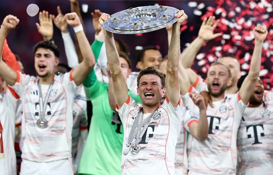 El futbolista alemán Thomas Müller, del Bayern Múnich, alza el trofeo de campeón de la Bundesliga, este 10 de mayo de 2025, en el estadio Allianz Arena. EFE/Anna Szilagyi