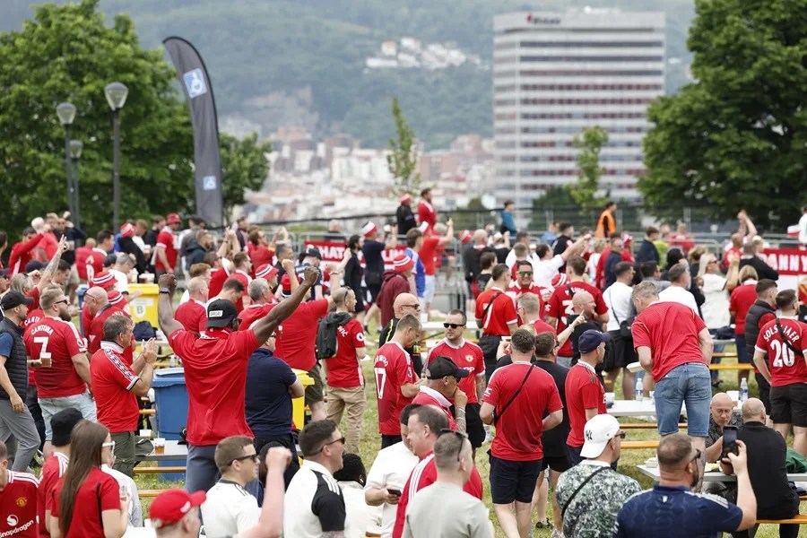 Aficionados del Manchester United se divierten en su 'fan zone', ubicada en el parque Etxebarria de Bilbao,