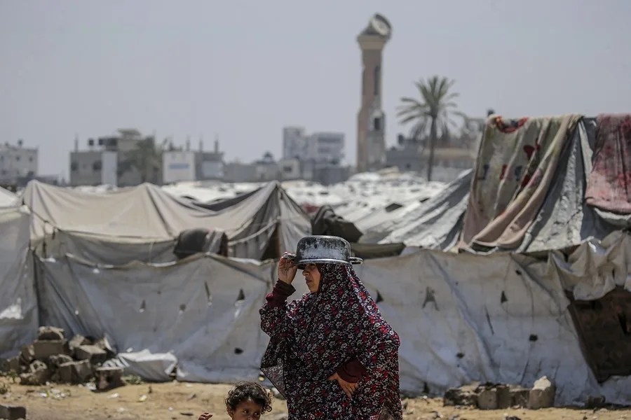 Una mujer palestina desplazada interna espera recibir una ración de comida de un comedor social en el campo de refugiados de Jabalia