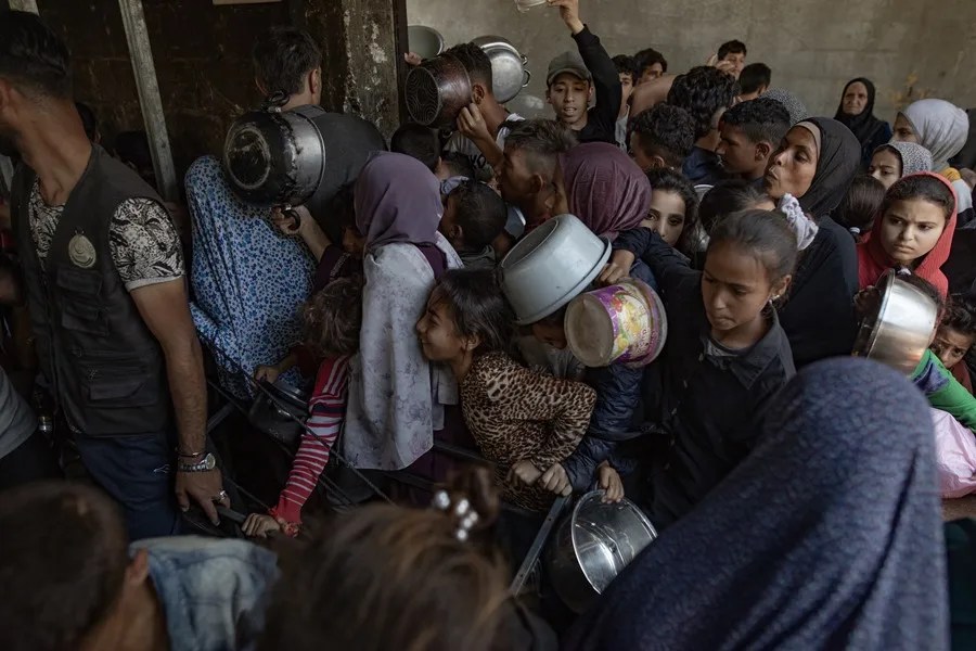 Cientos de palestinos se amontonan frente al Comedor Social Sokar en la Ciudad de Gaza