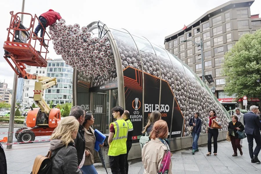 Un operario coloca balones en una boca de metro de la capital vizcaína con motivo del la final.