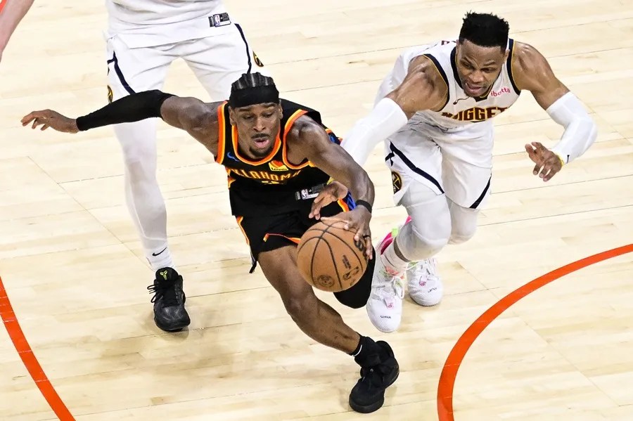 Shai Gilgeous-Alexander, conduce contra el base de los Denver Nuggets, Russell Westbrook,