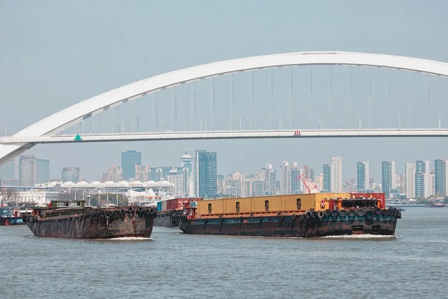 Una fotografía aérea muestra un carguero navegando por el río Huangpu en Shanghái.