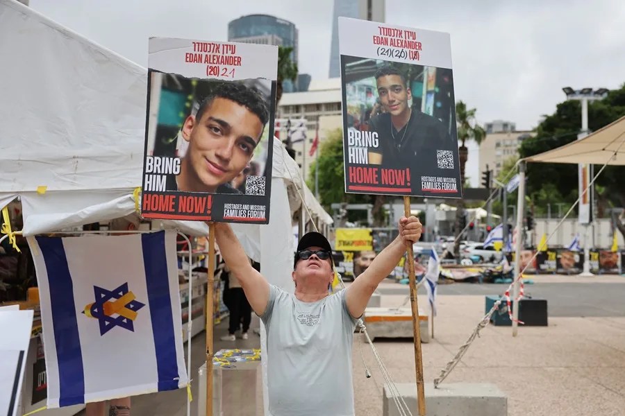 Un hombre sostiene fotos del soldado israelí-estadounidense Edan Alexander
