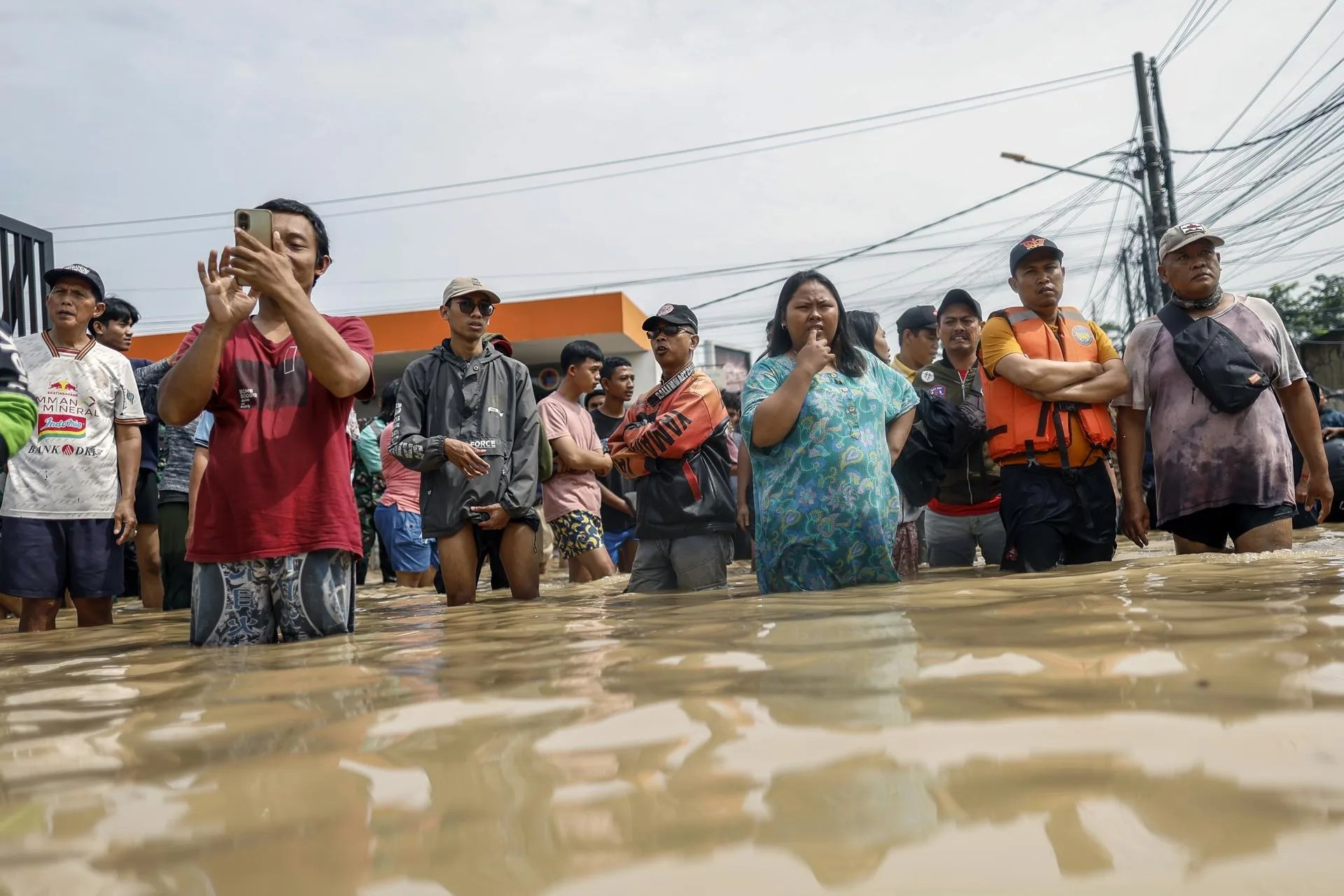 People stand in flood water in a residential area of Bekasi, West Java, Indonesia, 04 March 2025. EFE/EPA/MAST IRHAM