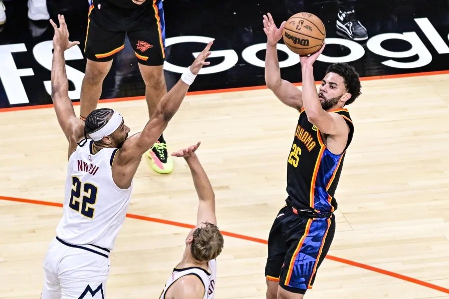 El base del Oklahoma City Thunder, Ajay Mitchell (der.), dispara contra el alero de los Denver Nuggets, Zeke Nnaji