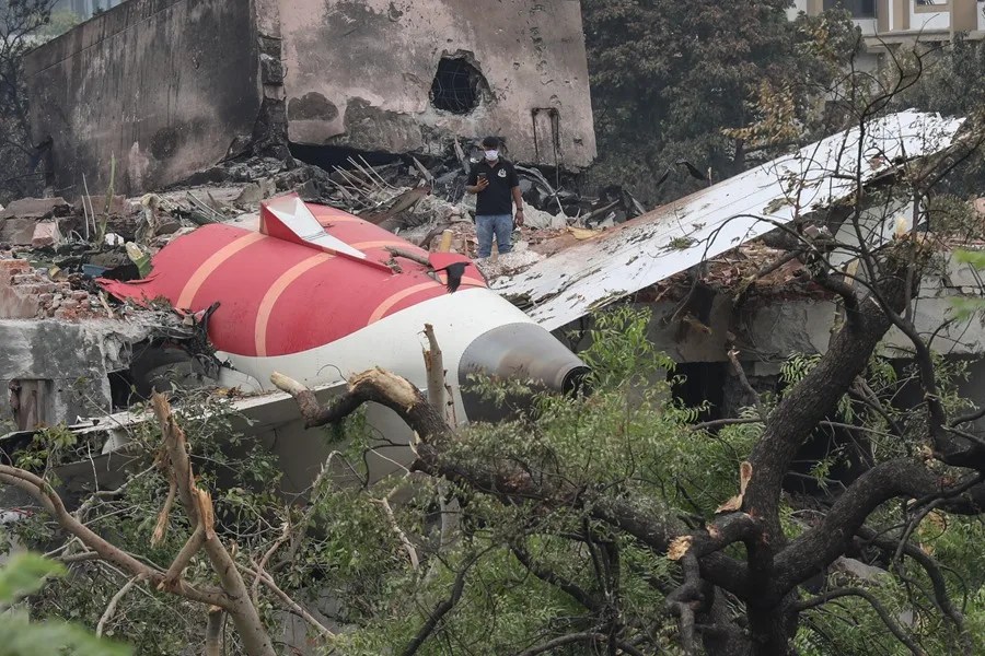 Un funcionario inspecciona el lugar del accidente aéreo cerca del Aeropuerto Internacional Sardar Vallabhbhai Patel en Ahmedabad