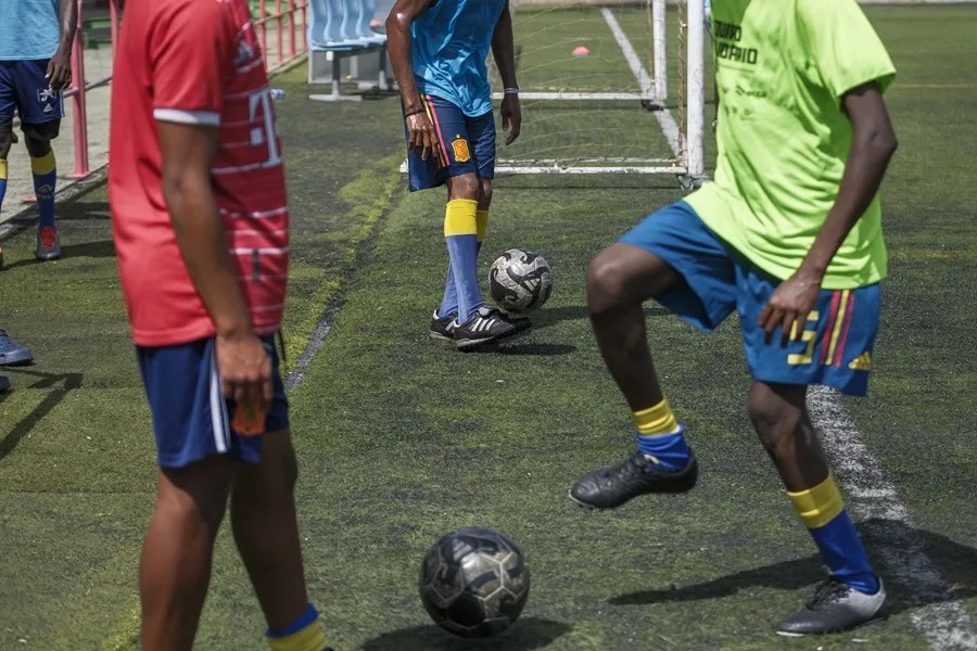 Unos menores migrantes juegan al fútbol.