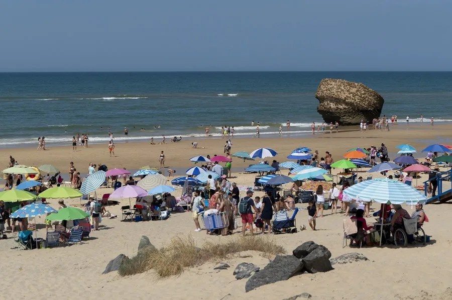 Decenas de personas disfrutan de la mañana del domingo en la playa de Matalascañas de Huelva.