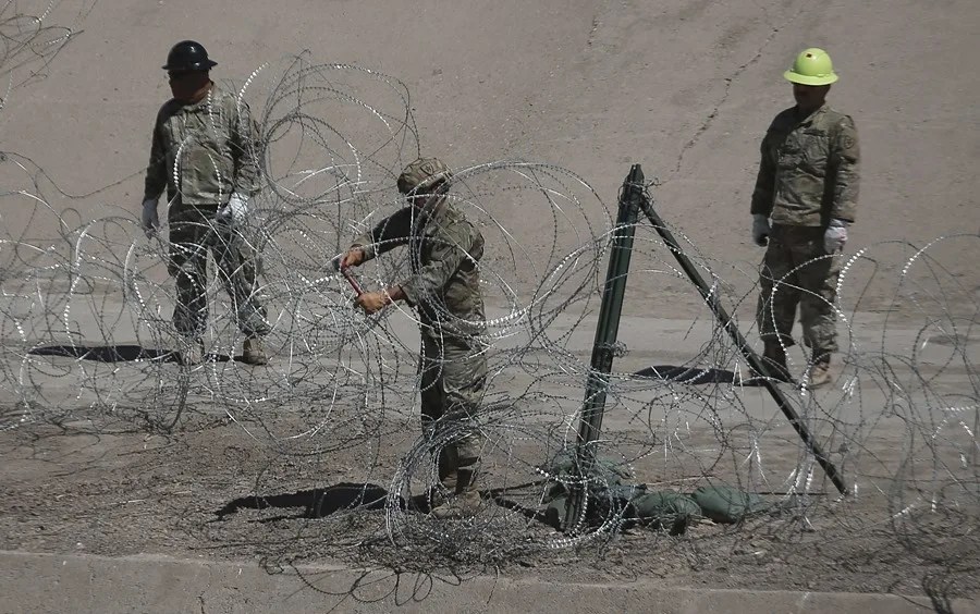 Integrantes de la Guardia Nacional de Texas instalan alambres de púas en la frontera con México este miércoles, en Ciudad Juárez (México). 