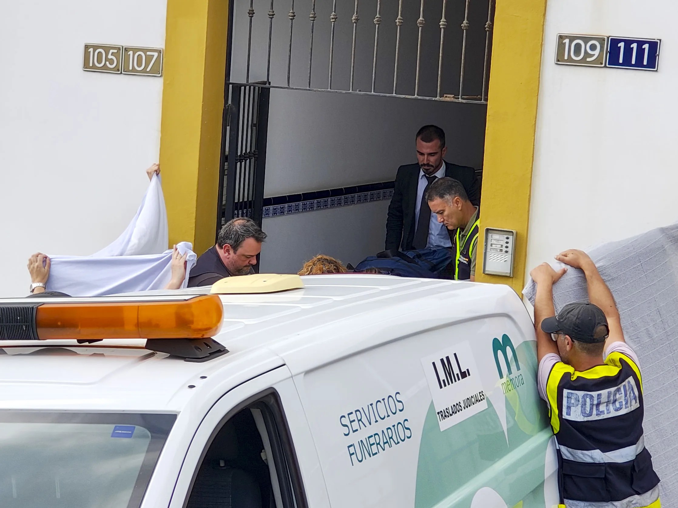 Operarios de una funeraria retiran los cadáveres de la vivienda donde se produjeron los hechos. EFE/Christian Afonso