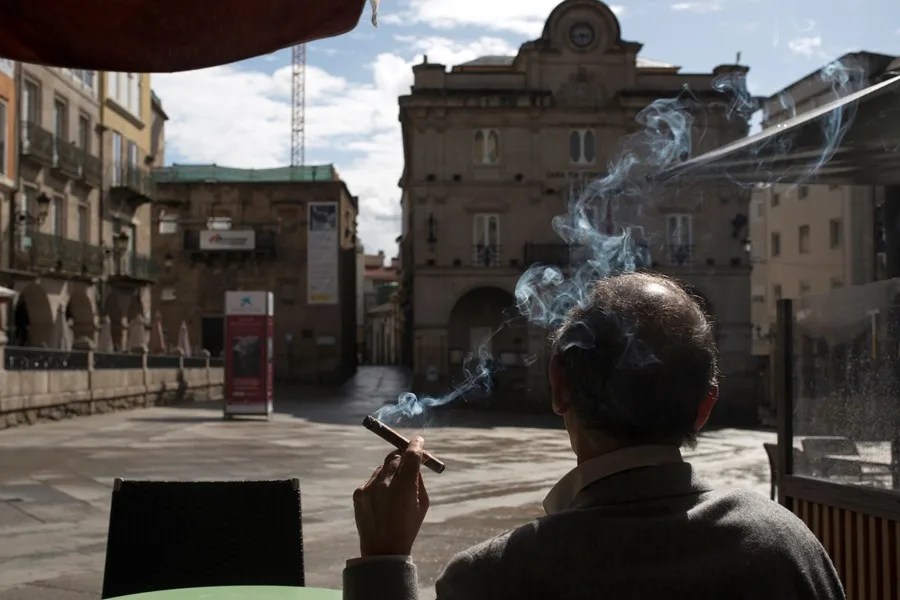 Un hombre fuma sentado en una terraza