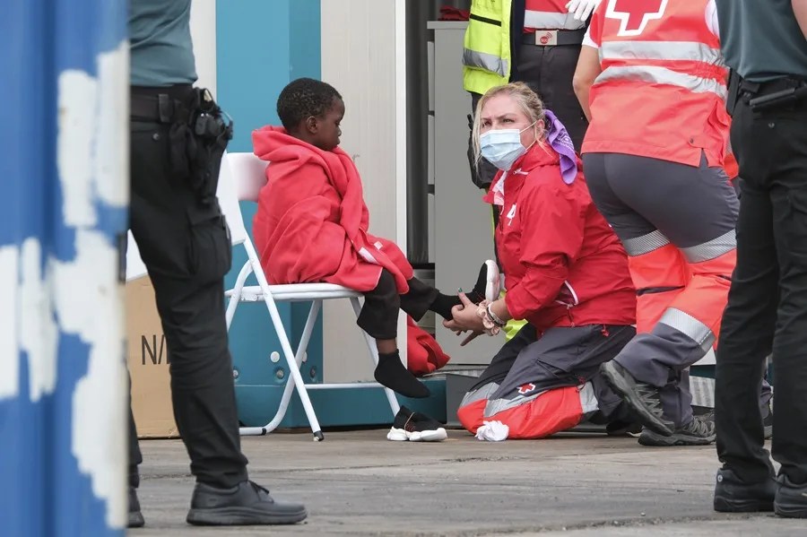 Un grupo de personas migrantes, entre ellos varios menores, es atendido por la Cruz Roja