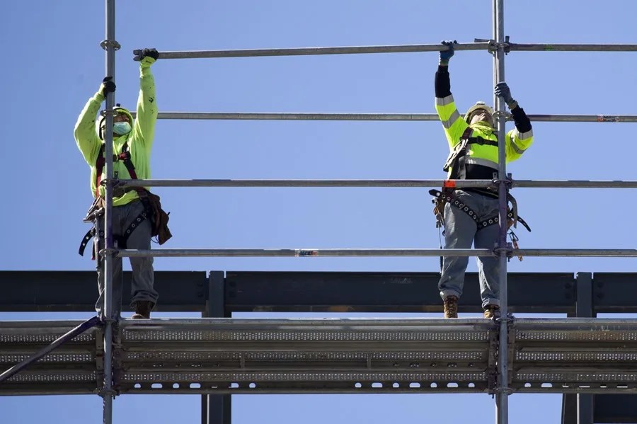Trabajadores construyen un andamio.