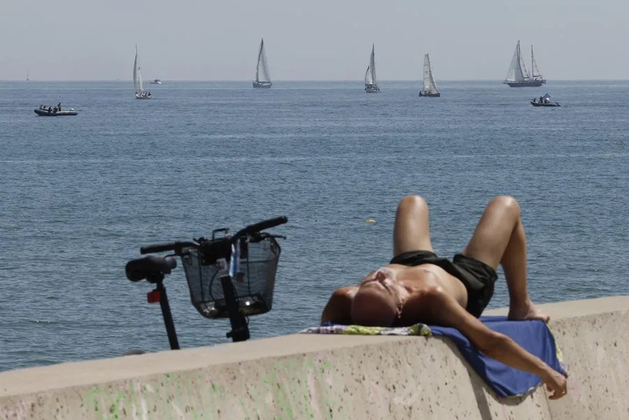 Cientos de personas disfrutan de un domingo soleados en la playa de Las Arenas de Valencia.