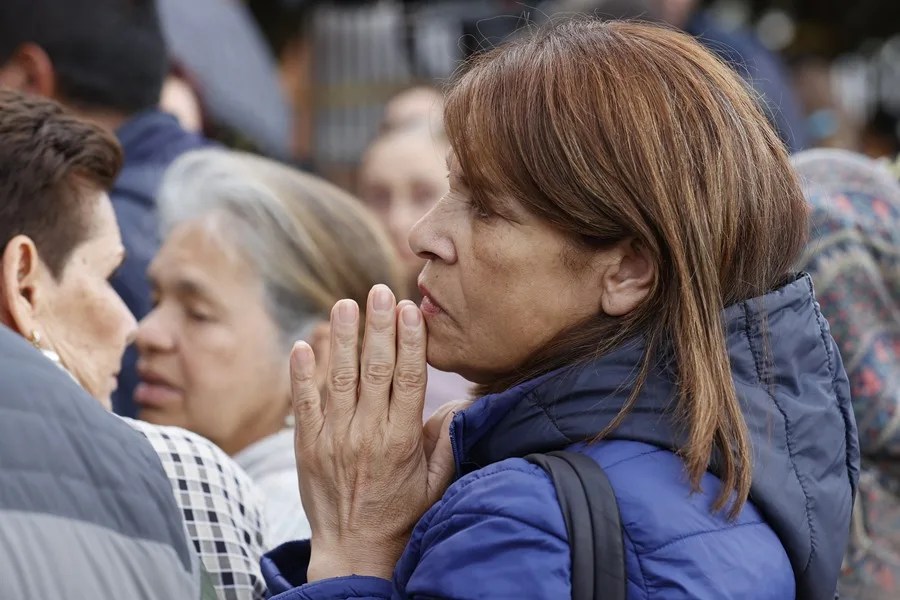 Una mujer reza por la salud del senador Miguel Uribe este martes, frente a la Clínica Fundación Santa Fe de Bogotá (Colombia).