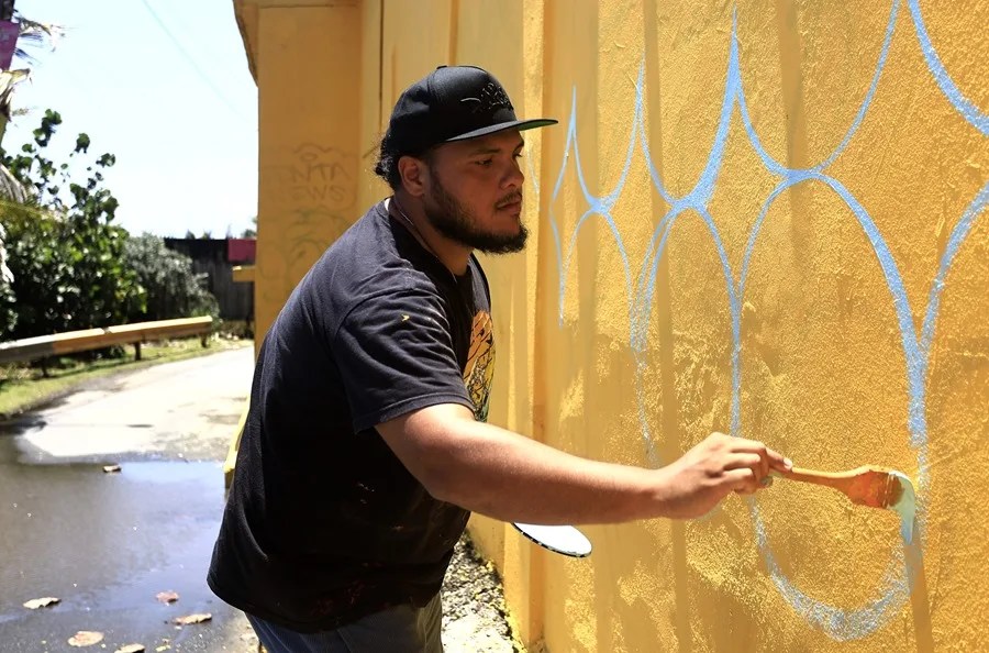 El artista Rafael Enrique 'Rafique' Vega pinta un mural este miércoles, en la Perla en San Juan (Puerto Rico). EFE/ Thais Llorca