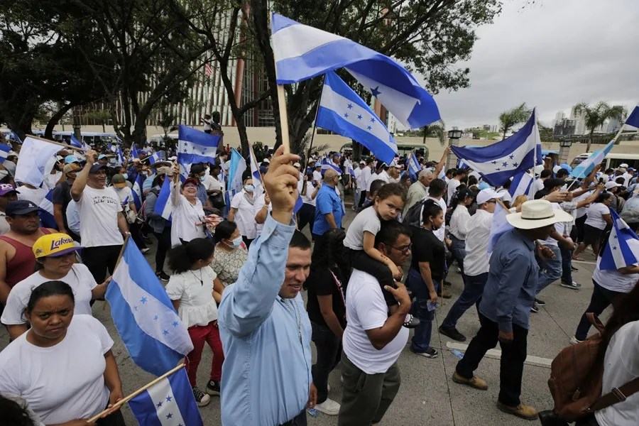 Personas sostienen banderas durante una manifestación convocada por el candidato presidencial por el Partido Nacional, Nasry Asfura, este domingo en Tegucigalpa (Honduras). EFE/ Gustavo Amador