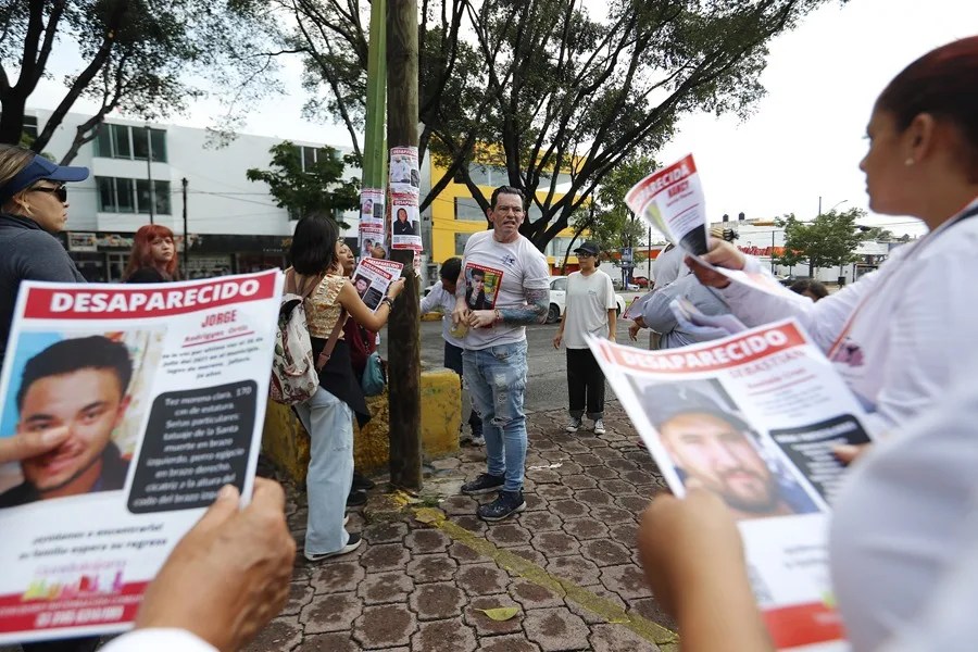 Integrantes de colectivos de búsqueda pegan carteles de personas desaparecidas en Guadalajara (México). EFE/Francisco Guasco