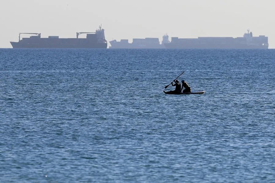 Dos personas disfrutan del paddle surf en aguas de la playa de El Saler (Valencia).