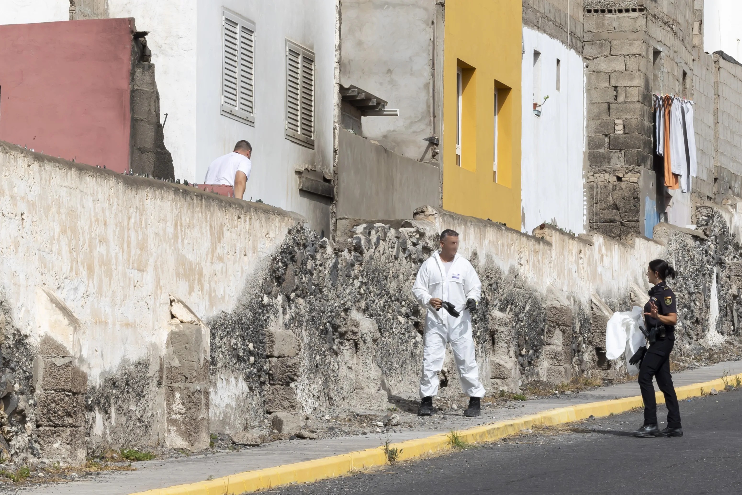 Agentes policiales registran el inmueble donde sucedieron los hechos. EFE/Quique Curbelo