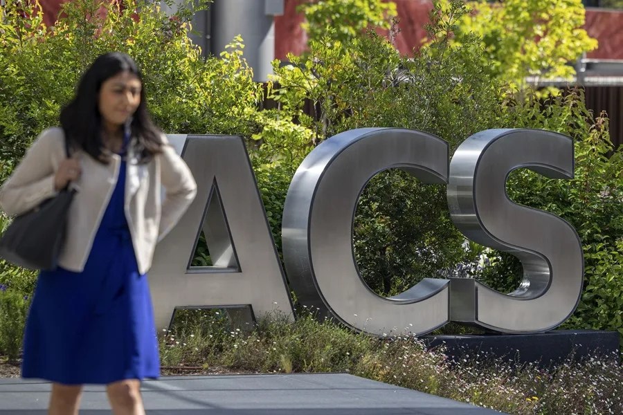Una persona pasa delante de la sede de ACS en Madrid.