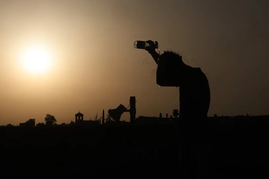 Una persona se refresca al atardecer en una jornada de altas temperaturas en la ciudad de Córdoba