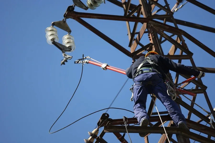Un operario trabaja encima de la catenaria