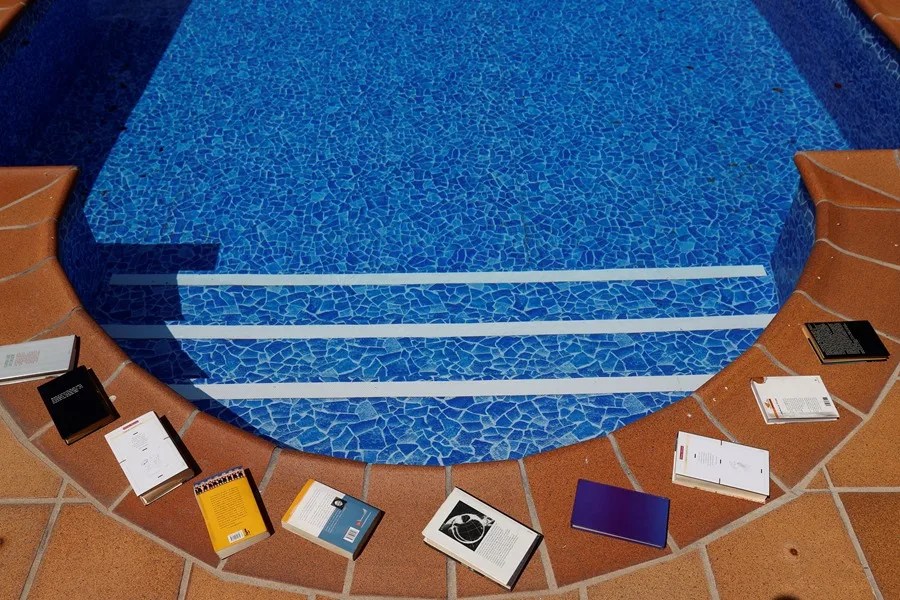 Libros sobre una piscina.