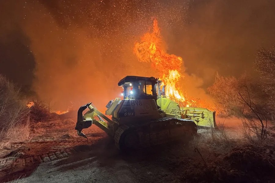 Maquinaria pesada en la lucha esta noche contra el incendio en Aguasmestas, una parroquia del municipio de Quiroga, en la provincia de Lugo.