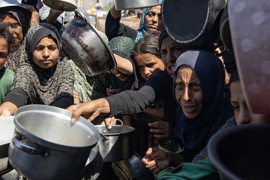 Palestinos hacen cola para recibir comida