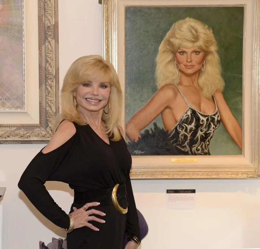 La actriz Loni Anderson posa frente a un retrato.