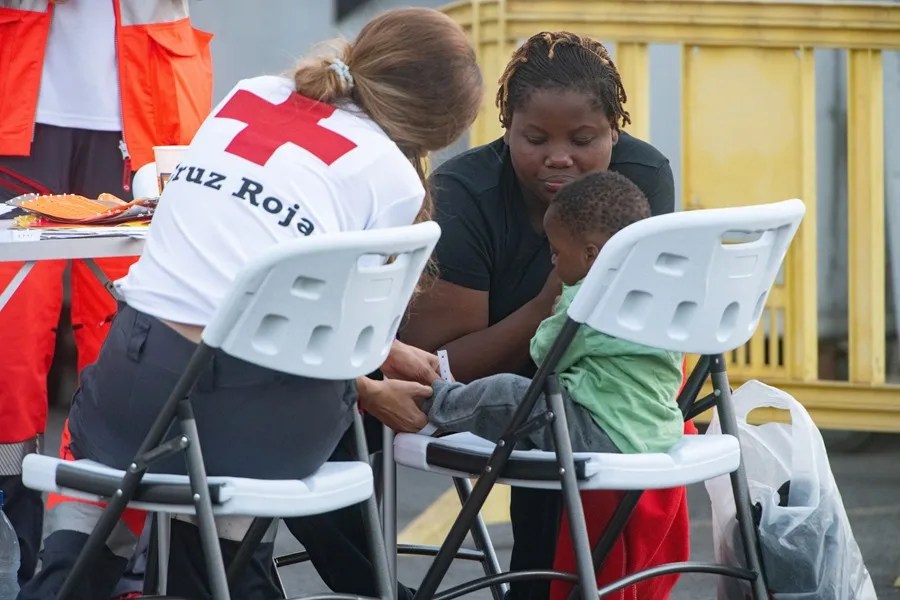 Una miembro de la Cruz Roja atiende a un niño en Canarias.
