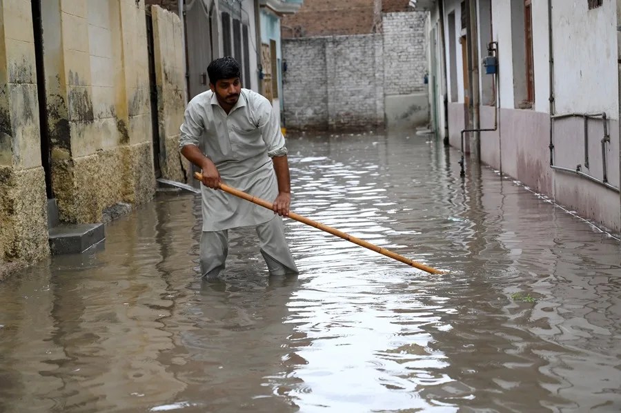 Un hombre camina entre las fuertes lluvias monzónicas en Peshawar, provincia de Khyber Pakhtunkhwa