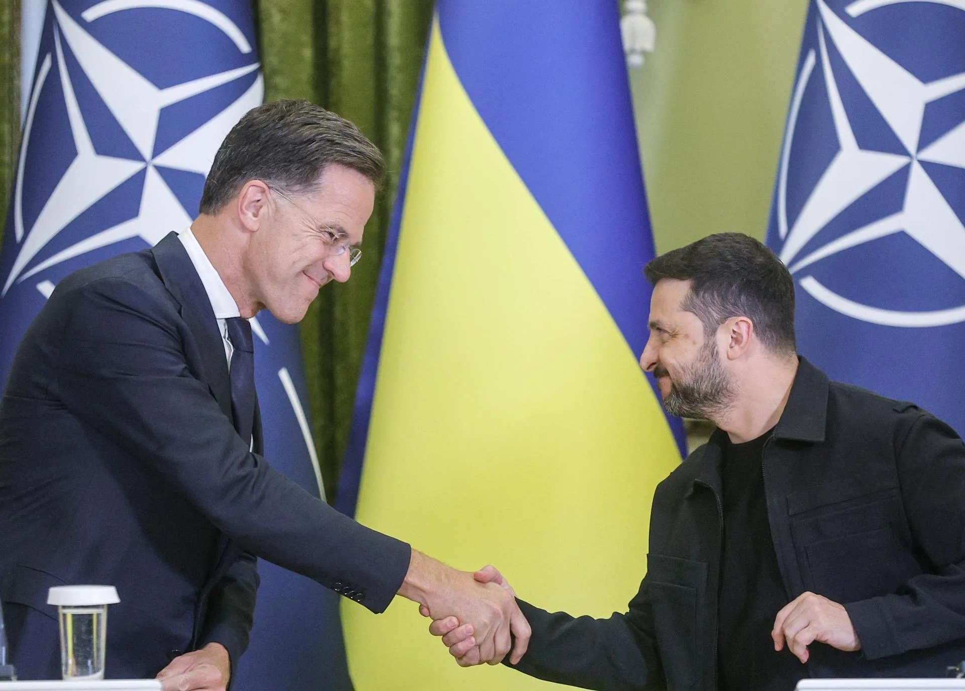 El Secretario General de la OTAN Mark Rutte (I) y el Presidente de Ucrania Volodymyr Zelensky (D) se dan la mano durante una conferencia de prensa conjunta tras su reunión en Kiev, Ucrania, 22 de agosto de 2025. El Secretario General de la OTAN llegó a Kiev para reunirse con altos funcionarios ucranianos, en medio de la invasión rusa en curso. (Ucrania, Kiev) EFE/SERGEY DOLZHENKO