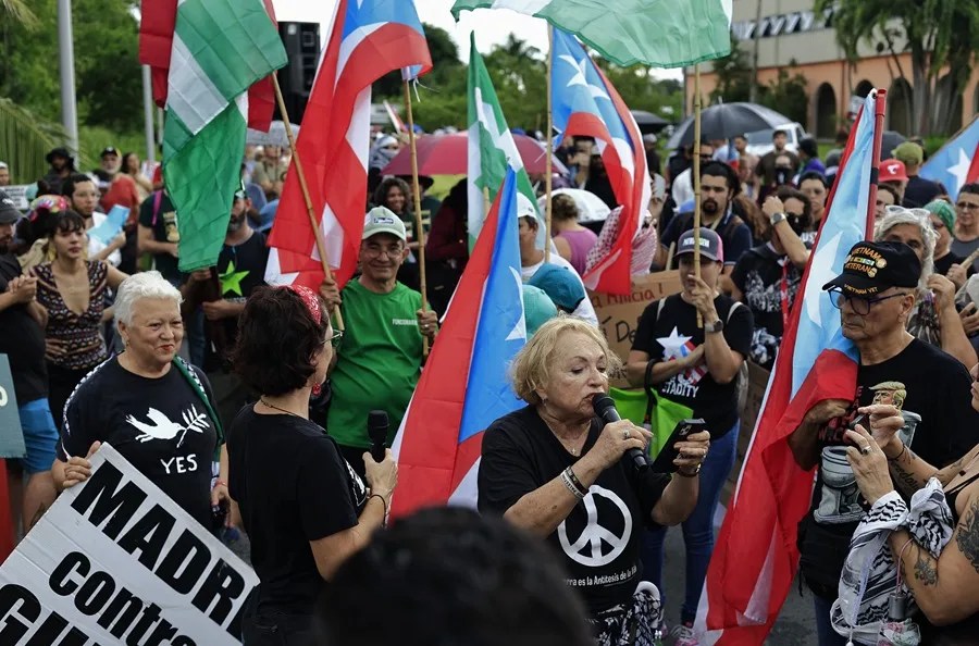 Sonia Santiago (c-abajo) del colectivo Madres Contra le Guerra se manifiesta en rechazo a las maniobras del Ejército de Estados Unidos en Puerto Rico, en Carolina (Puerto Rico). EFE/ Thais Llorca