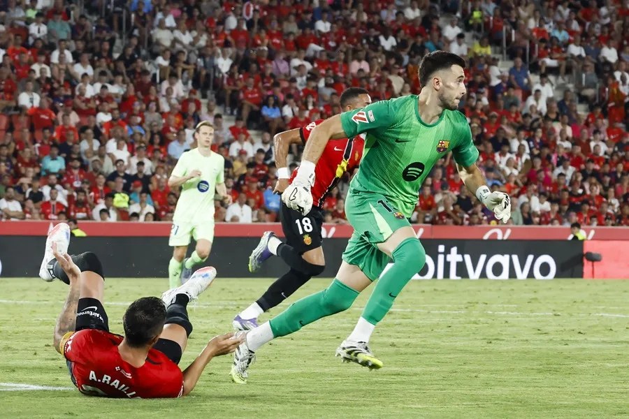 El guardameta del FC Barcelona Joan García (d) disputa un balón con el defensa del Mallorca Antonio Raíllo (i)