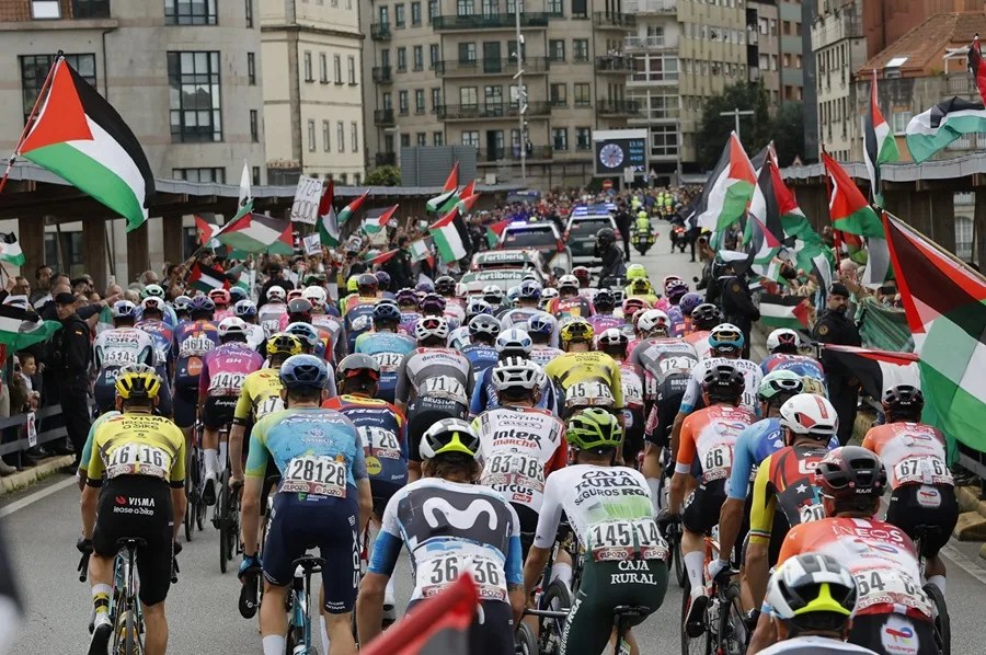 El pelotón pasa ante la protestas propalestina durante la etapa 16 de la Vuelta Ciclista a España