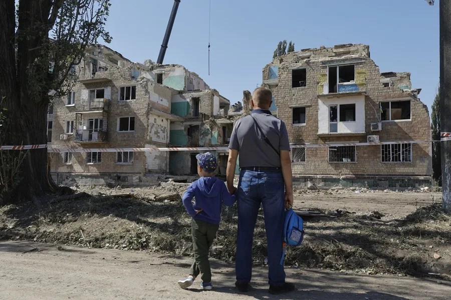 Los ucranianos observan el lugar de un ataque ruso que el día anterior golpeó un edificio residencial de cinco pisos en Kiev