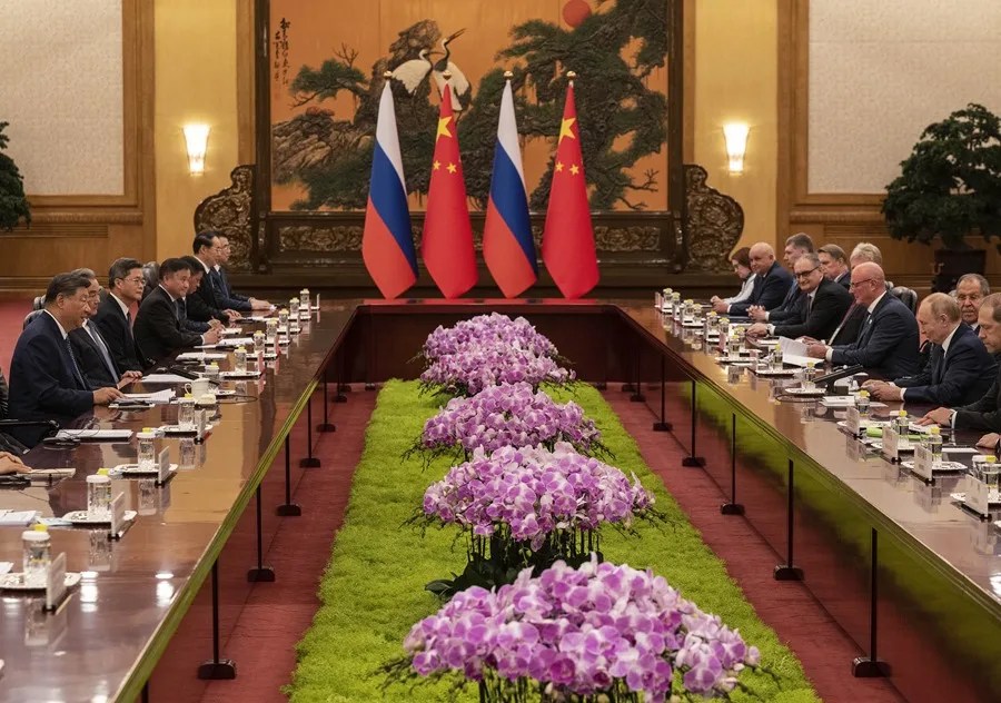 El presidente ruso, Vladímir Putin (3-d), habla al inicio de una reunión bilateral con el presidente chino, Xi Jinping (5-i), en el Gran Palacio del Pueblo en Pekín